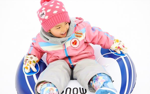 Child enjoying snow tubing at Greenpia Onuma Ski Resort.