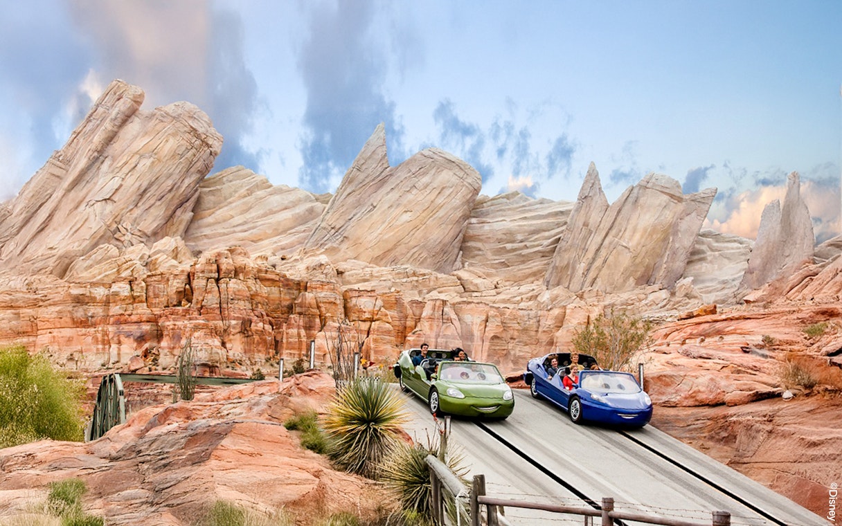 Cars on adventure track at Disneyland Adventure Park, California with rocky backdrop.