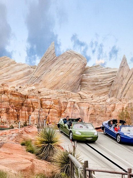 Cars on adventure track at Disneyland Adventure Park, California with rocky backdrop.