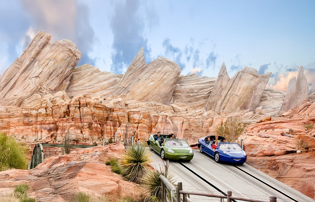 Cars on adventure track at Disneyland Adventure Park, California with rocky backdrop.
