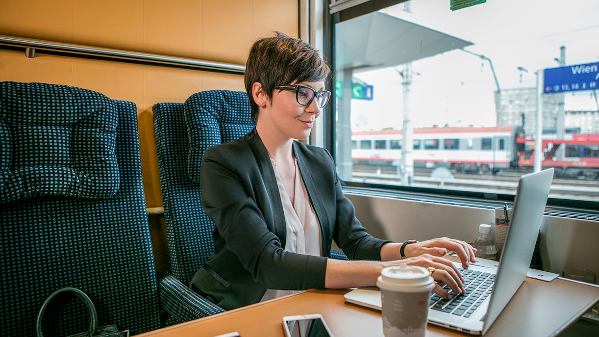 Professional woman in train working on first class seat