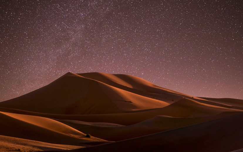 Starlit sky over sand dunes at Doha desert safari.