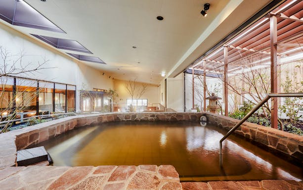 Indoor bath area at Solaniwa Onsen with stone walls and natural lighting.