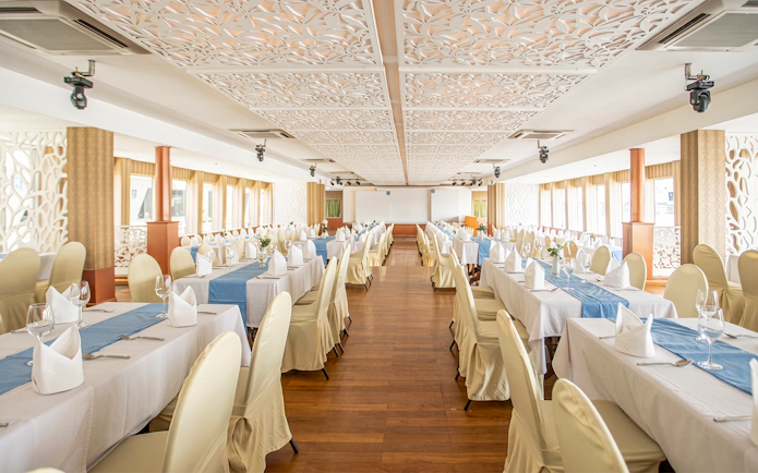Elegant dining setup on Riverside Faraya Cruise in Bangkok, featuring arranged tables and chairs.