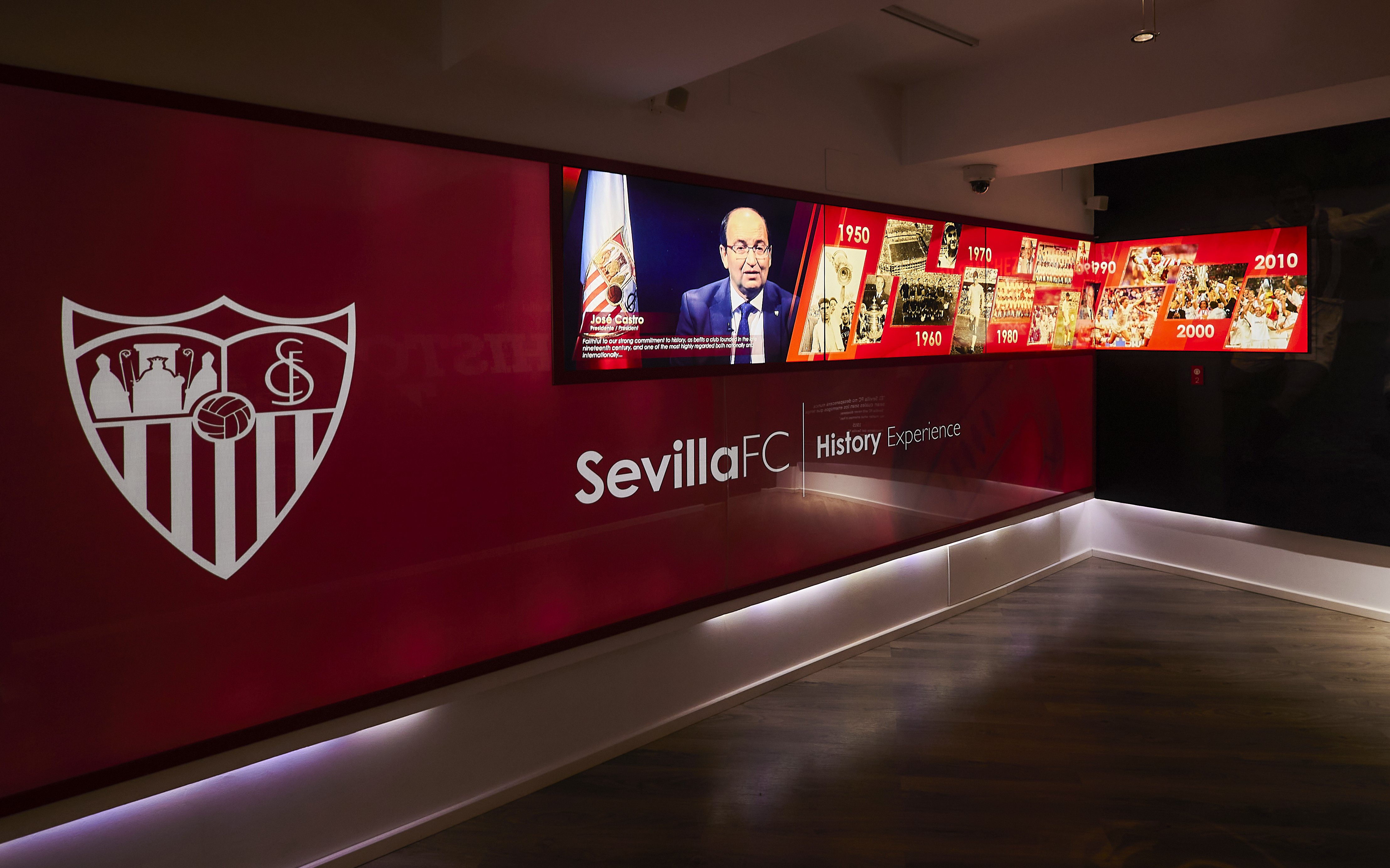 Sevilla FC History Experience museum exhibit with timeline and club emblem.