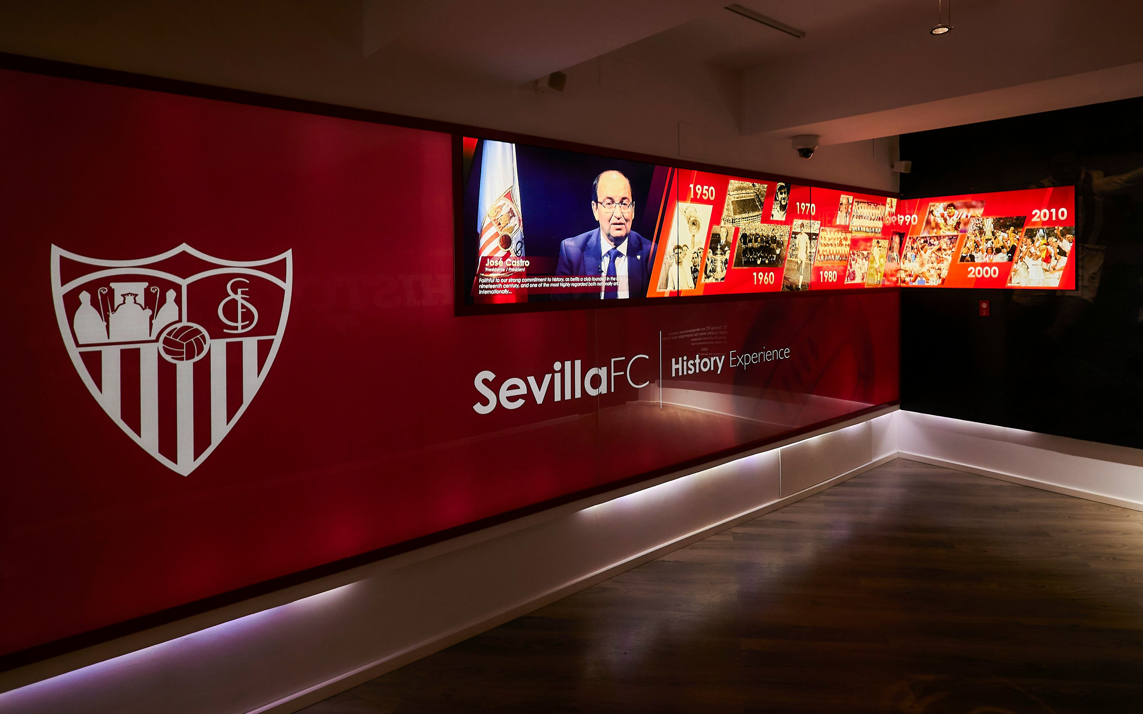 Sevilla FC History Experience museum exhibit with timeline and club emblem.