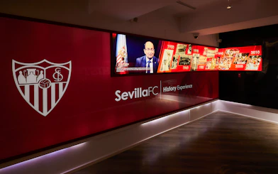 Sevilla FC History Experience museum exhibit with timeline and club emblem.