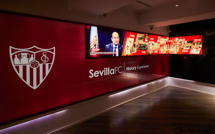 Sevilla FC History Experience museum exhibit with timeline and club emblem.