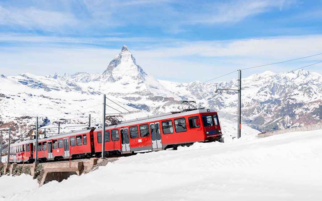 Gornergratbahn train approaching Gornergrat station with Matterhorn in the background.