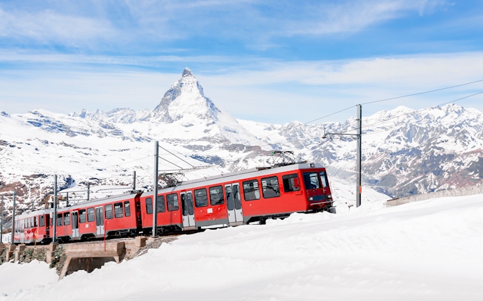 Gornergratbahn train approaching Gornergrat station with Matterhorn in the background.