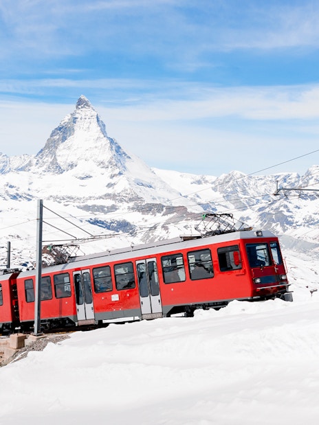 Gornergratbahn train approaching Gornergrat station with Matterhorn in the background.