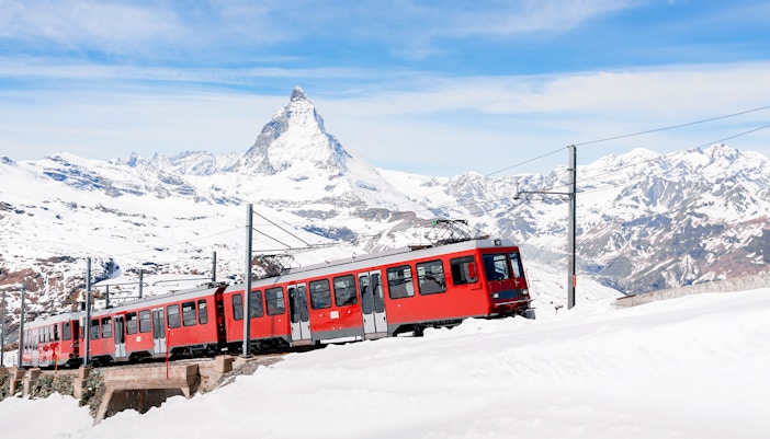 Gornergratbahn train approaching Gornergrat station with Matterhorn in the background.