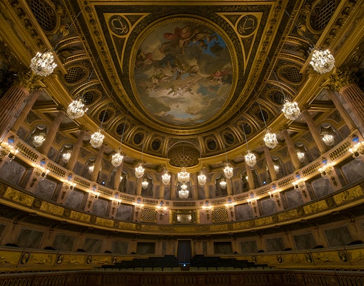 Royal Opera Versailles interior with ornate decorations and grand chandeliers.