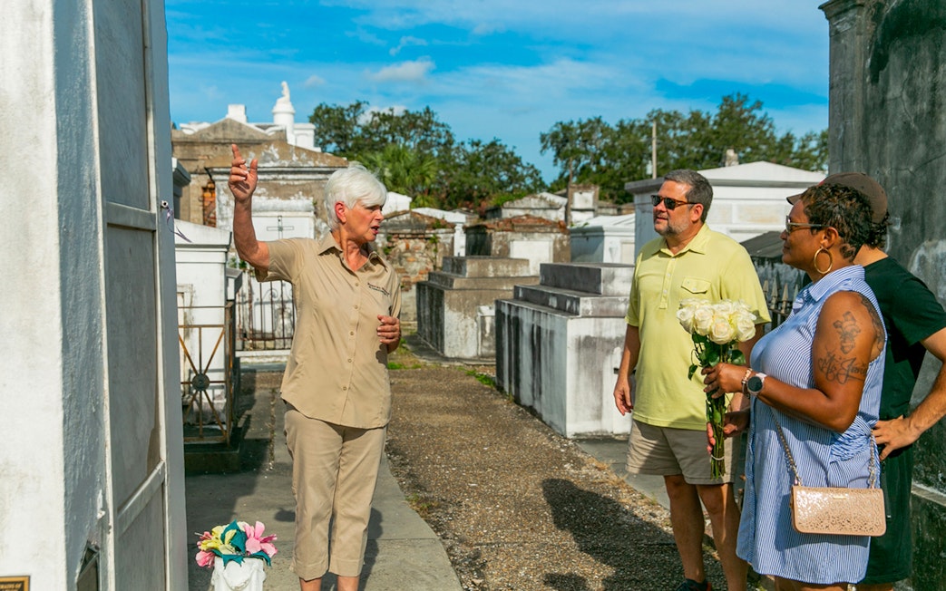 Tour guide explaining tombs to guests in St. Louis Cemetery, New Orleans.