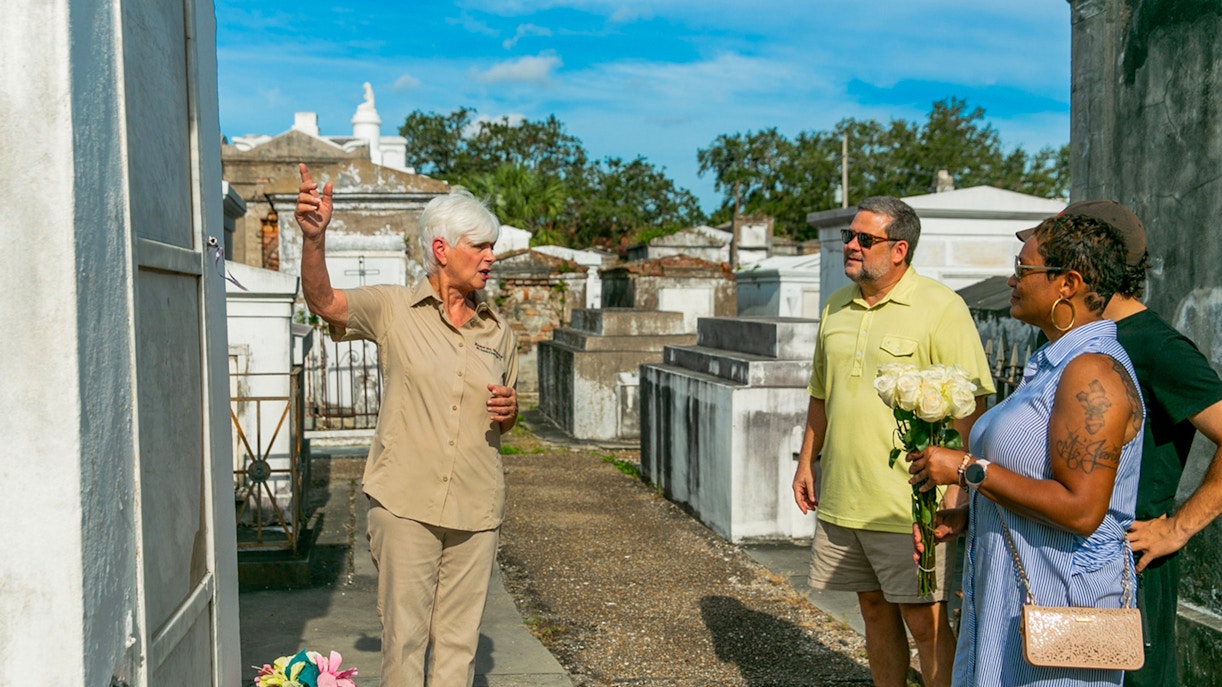 Tour guide explaining tombs to guests in St. Louis Cemetery, New Orleans.