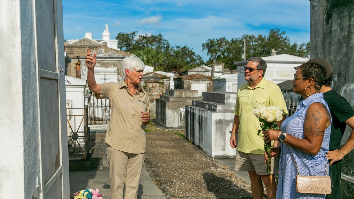 Tour guide explaining tombs to guests in St. Louis Cemetery, New Orleans.