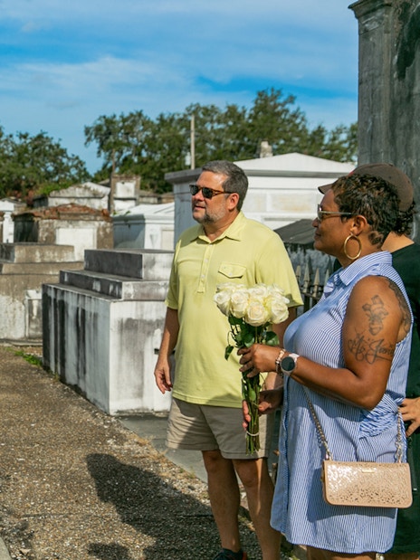 Tour guide explaining tombs to guests in St. Louis Cemetery, New Orleans.