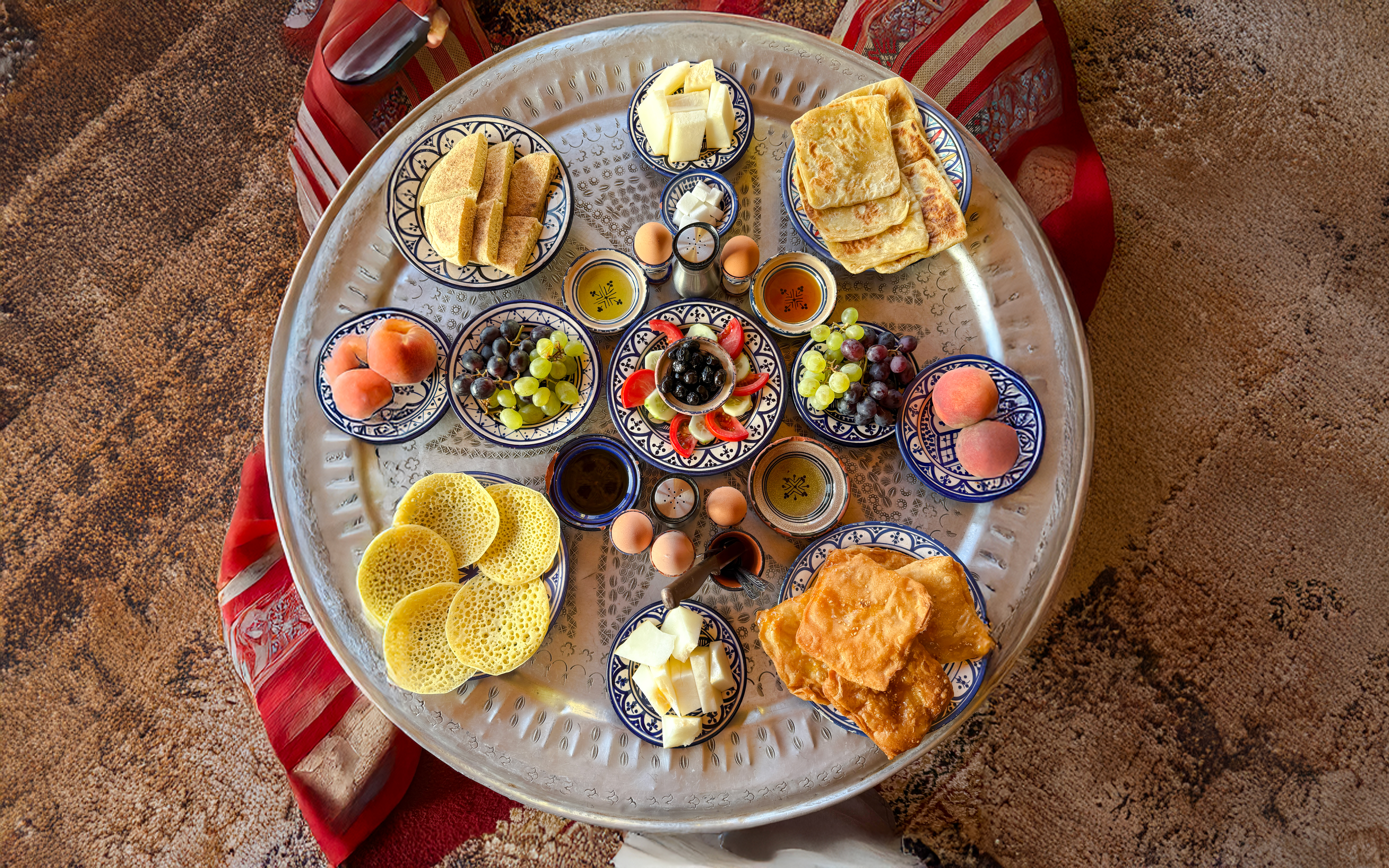 Traditional Berber breakfast spread with fruits and pastries in caidal tent, Marrakech.