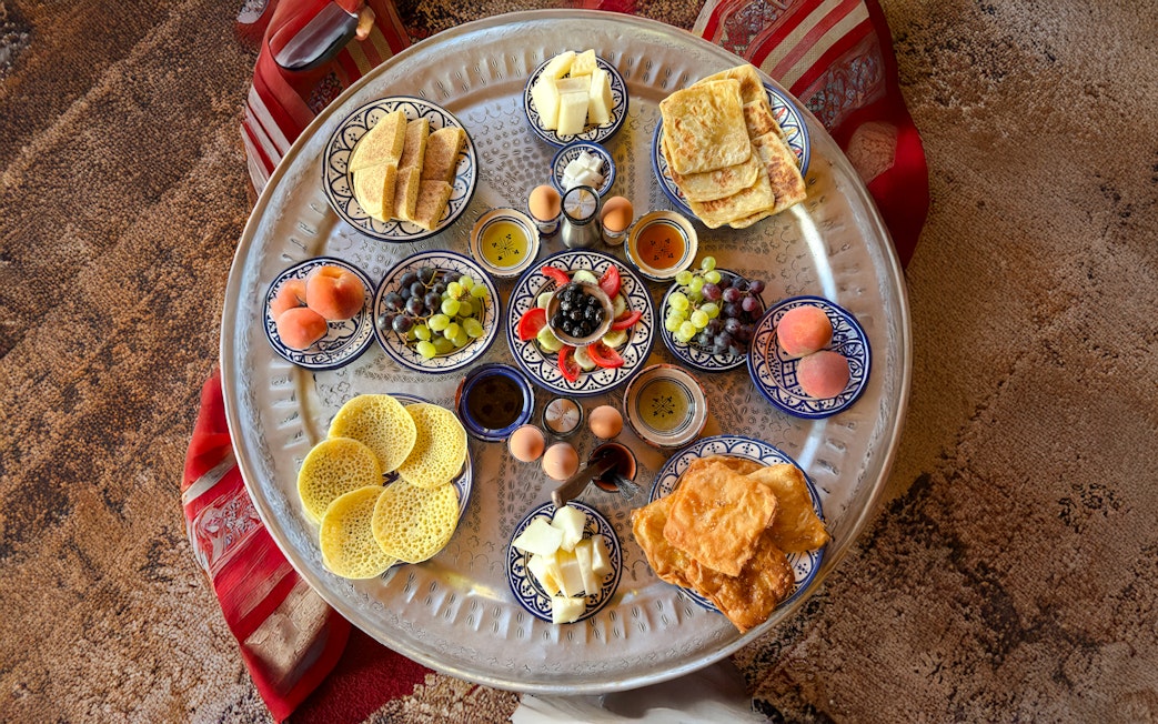 Traditional Berber breakfast spread with fruits and pastries in caidal tent, Marrakech.