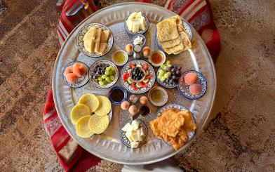 Traditional Berber breakfast spread with fruits and pastries in caidal tent, Marrakech.