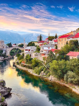 Mostar's Old Bridge over Neretva River with historic buildings, view from Dubrovnik tour.