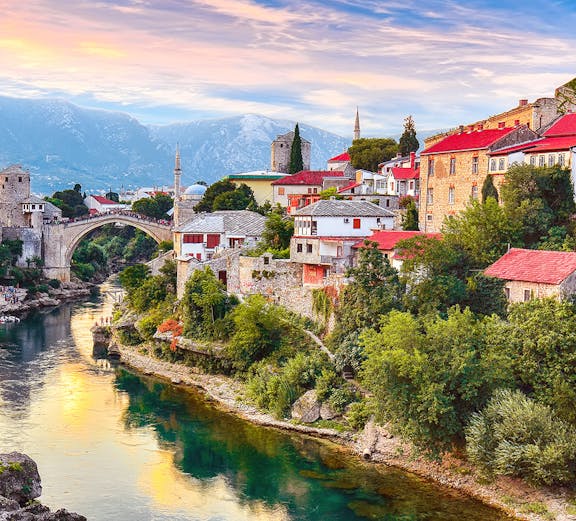 Mostar's Old Bridge over Neretva River with historic buildings, view from Dubrovnik tour.