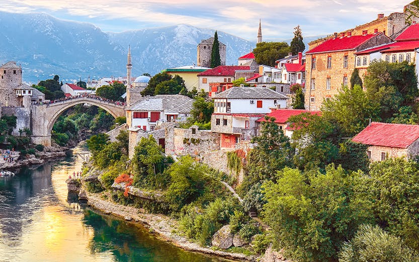 Mostar's Old Bridge over Neretva River with historic buildings, view from Dubrovnik tour.