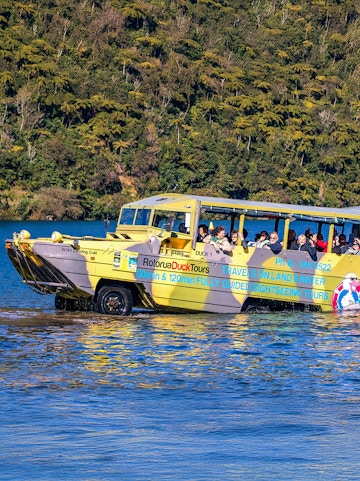Amphibious vehicle on Rotorua Duck Tours entering water with passengers, New Zealand.