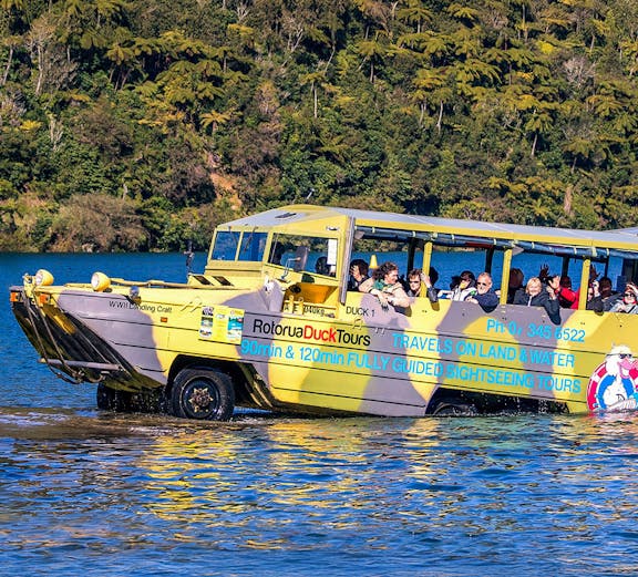 Amphibious vehicle on Rotorua Duck Tours entering water with passengers, New Zealand.