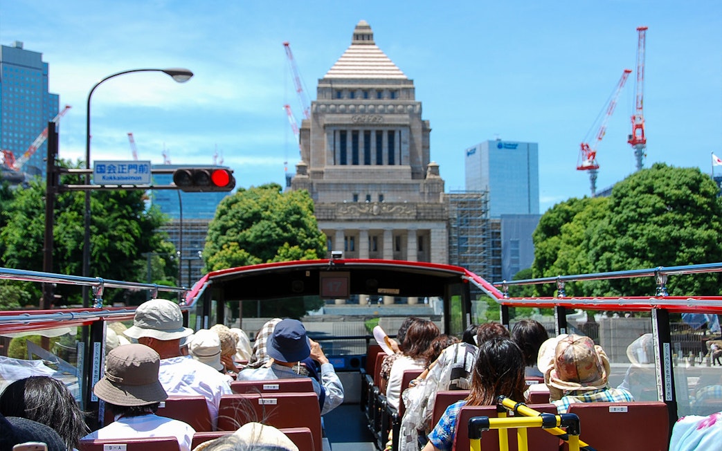 Open-top bus tour in Tokyo passing the National Diet Building.