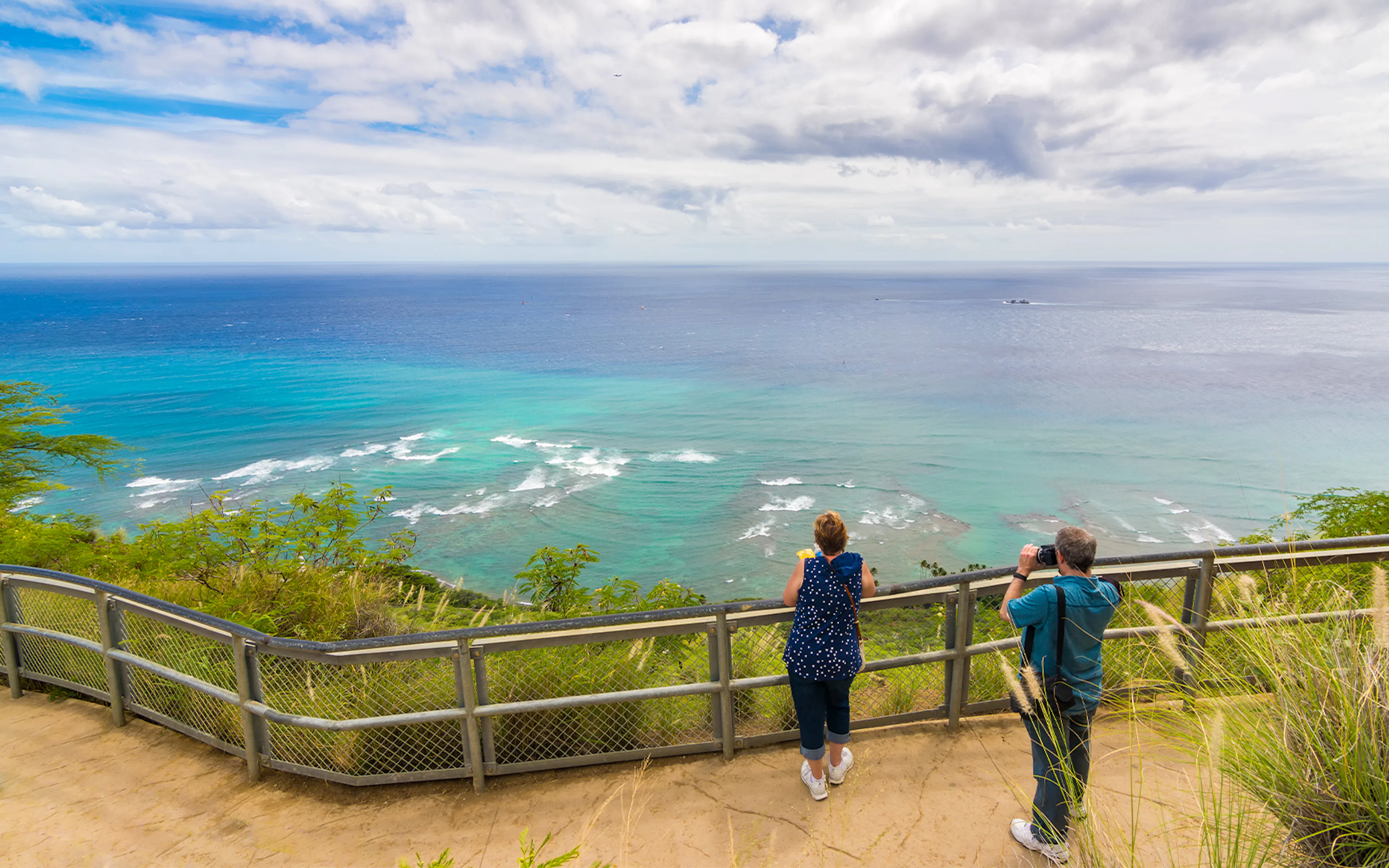 Visitors enjoying panoramic ocean view from Diamond Head State Monument, Oahu, Hawaii.