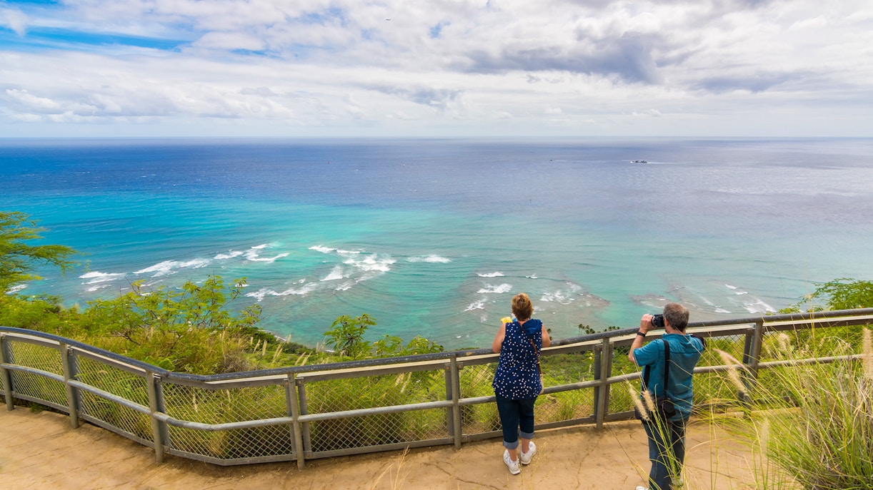 Visitors enjoying panoramic ocean view from Diamond Head State Monument, Oahu, Hawaii.