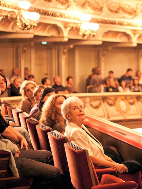 Guide leading a tour group inside the Semper Opera House, Dresden.