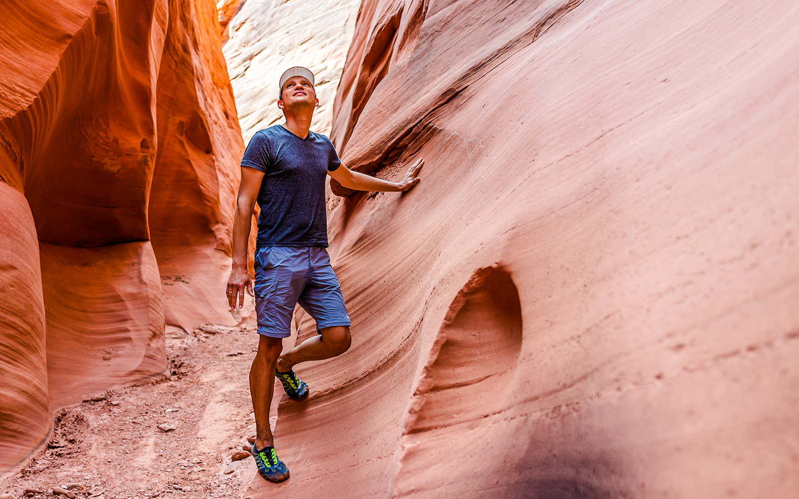 Hiker exploring narrow sandstone walls in Antelope Canyon.