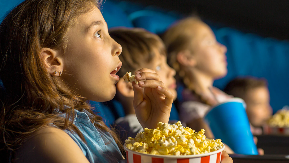 Kids enjoying popcorn at Dubai Butterfly Garden Kids Cinema.