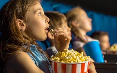 Kids enjoying popcorn at Dubai Butterfly Garden Kids Cinema.