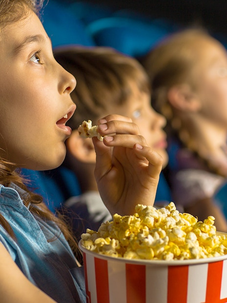 Kids enjoying popcorn at Dubai Butterfly Garden Kids Cinema.