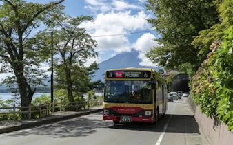 Kawaguchiko sightseeing bus with Mt. Fuji in the background on a sunny day.