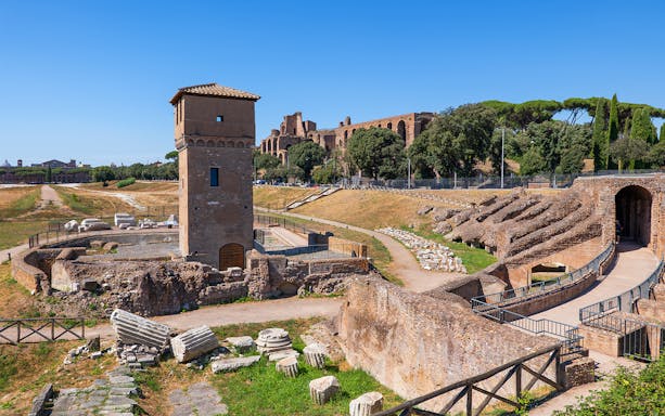 Circus Maximus ruins in Rome with ancient stone structures and a tower.