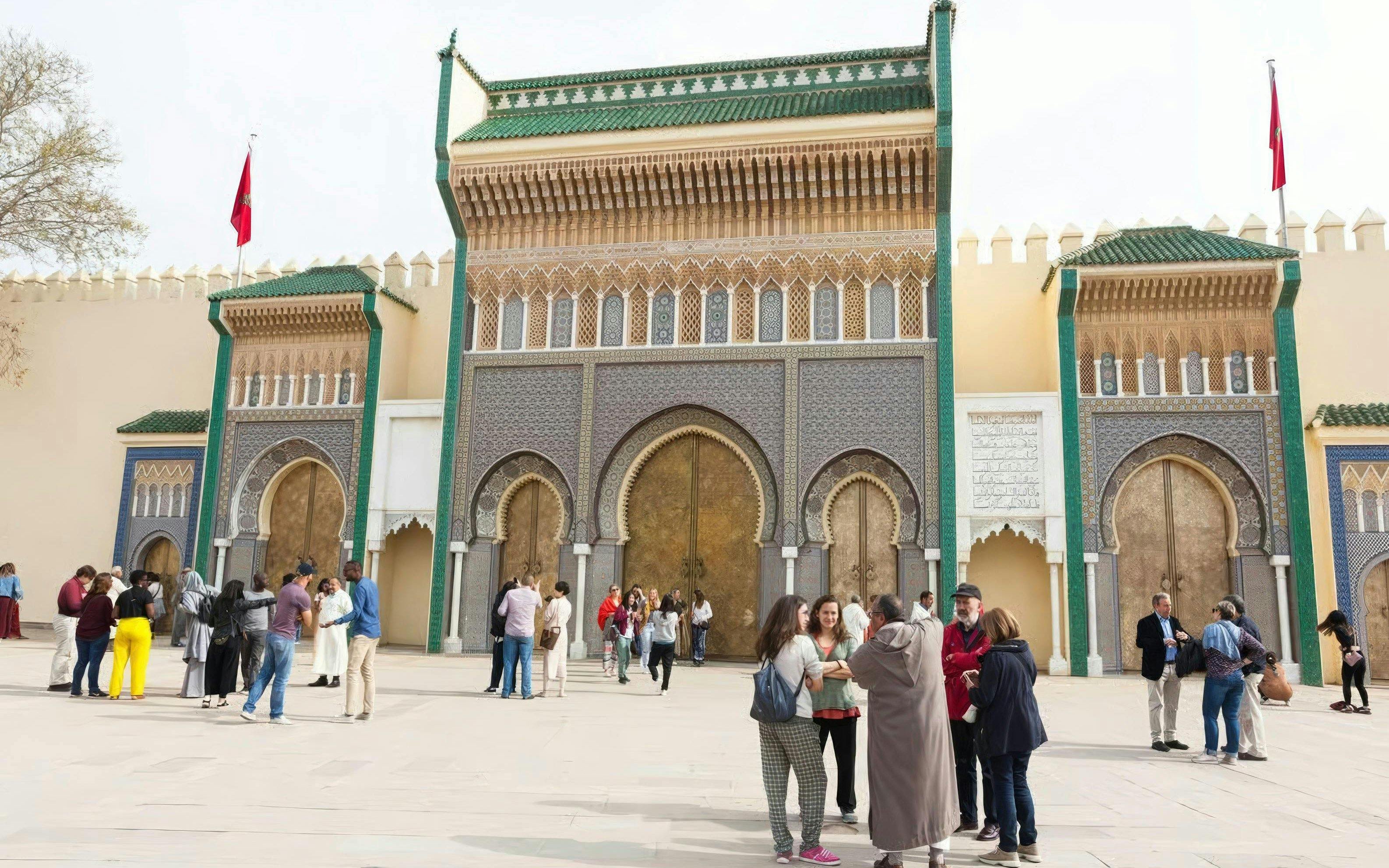 Visitors at the ornate entrance of the Royal Palace in Fes, Morocco.
