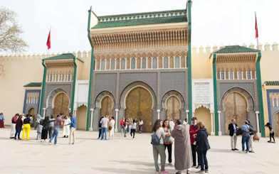 Visitors at the ornate entrance of the Royal Palace in Fes, Morocco.