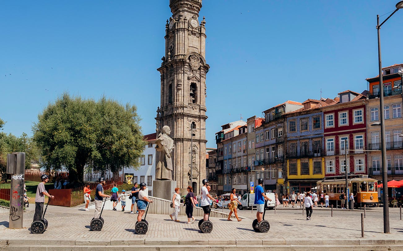 Tourists on Segways with guide near Clérigos Tower in Porto.