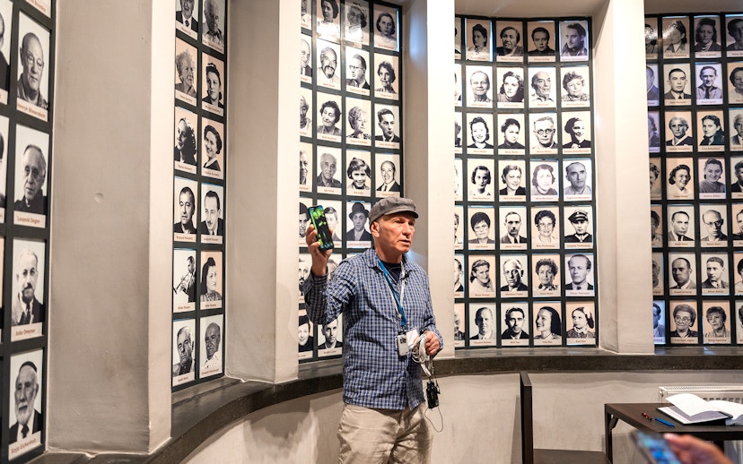 Guide explaining portraits of Oskar Schindler's factory employees during a tour.