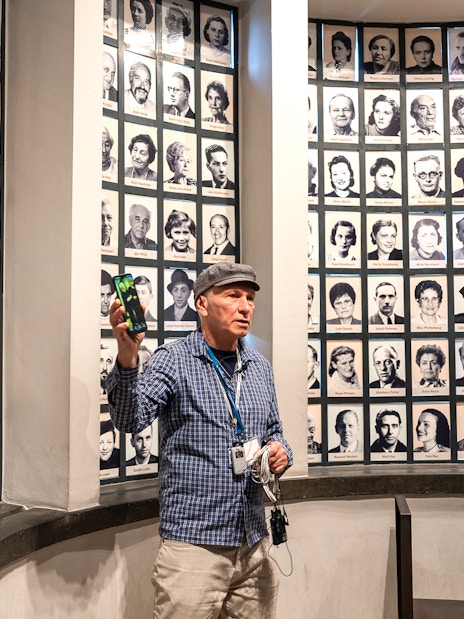 Guide explaining portraits of Oskar Schindler's factory employees during a tour.
