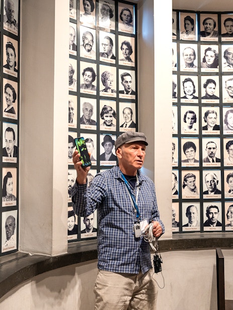 Guide explaining portraits of Oskar Schindler's factory employees during a tour.