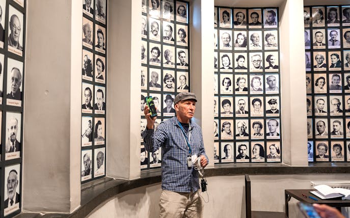 Guide explaining portraits of Oskar Schindler's factory employees during a tour.