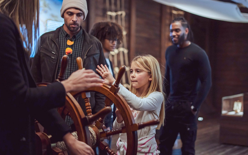 Visitors engaging with a ship's wheel at the Porto Region Across The Ages Experience.