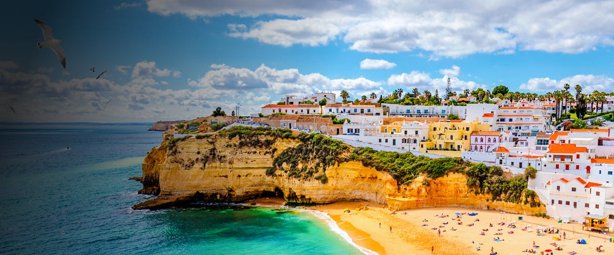 Cliffside village and beach in Algarve, Portugal with colorful buildings and ocean view.