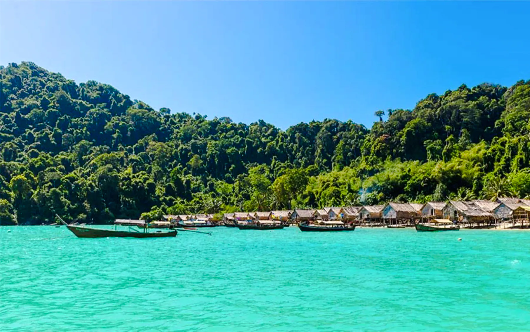 Speedboat near Moken Village with lush hills and turquoise water, Surin Islands, Krabi.