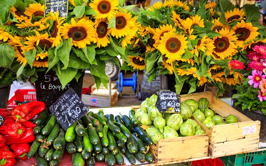 Sunflowers and fresh produce at a Provencal market stall.
